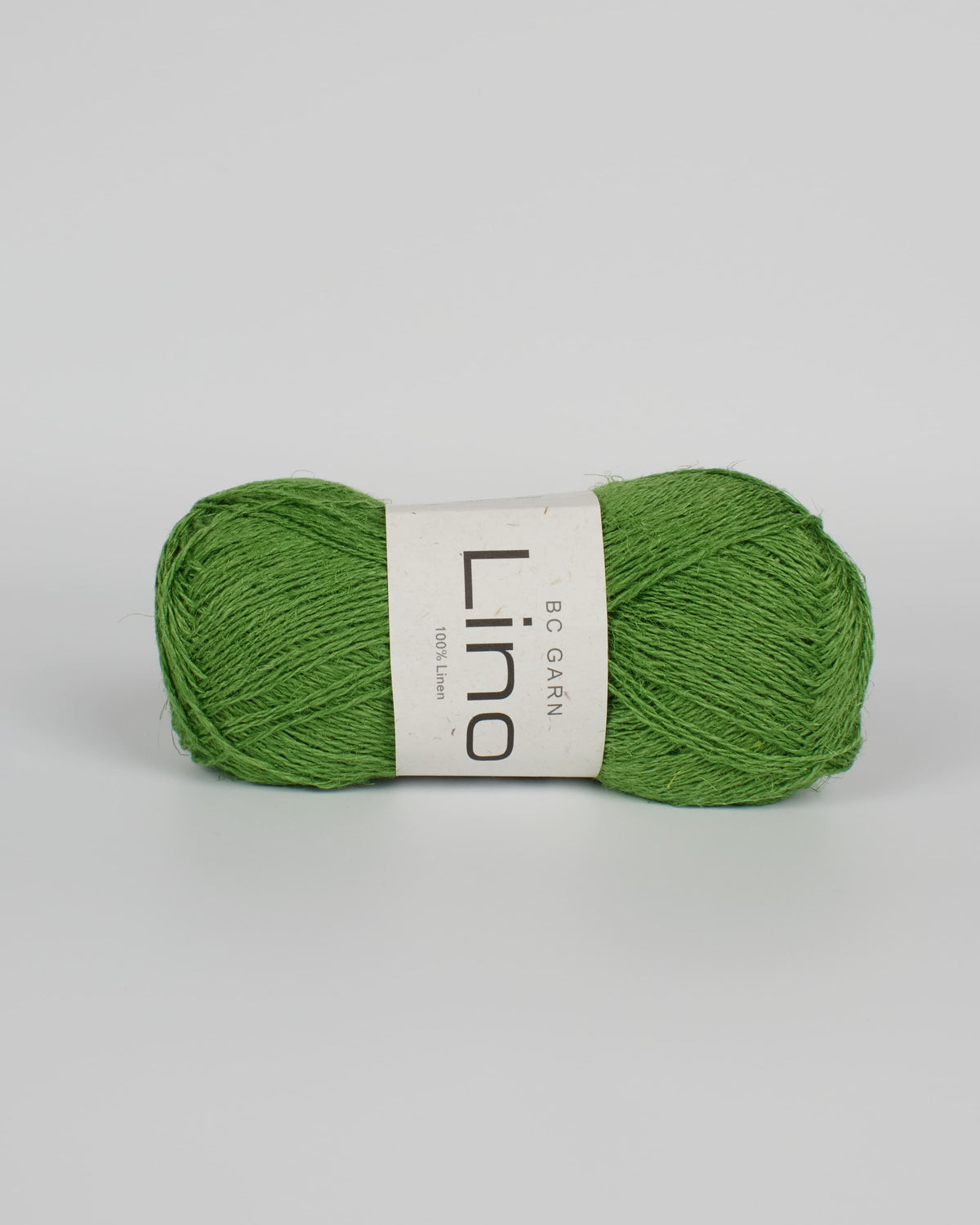 A apple green ball of linen yarn on a white background
