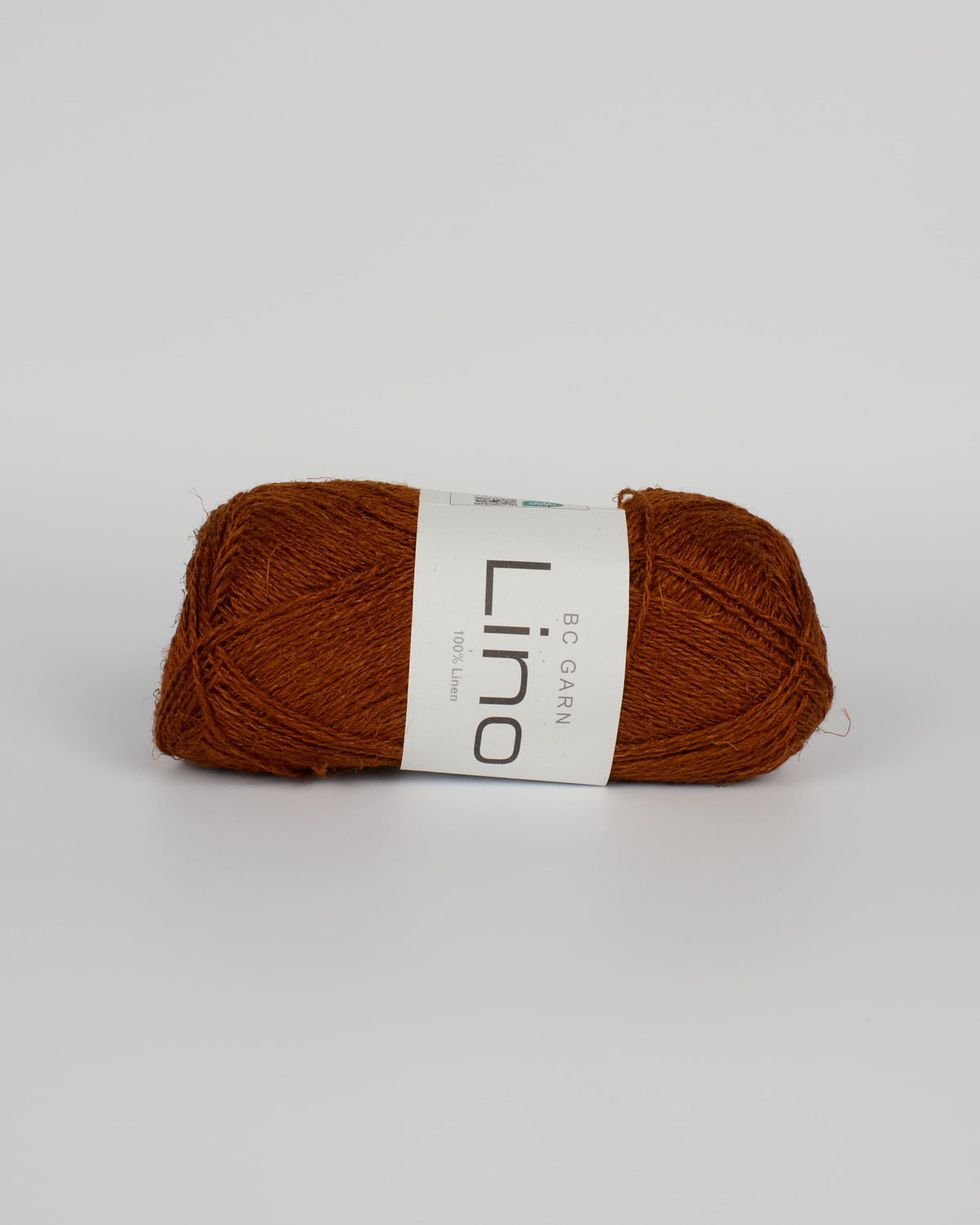 A caramel brown ball of linen yarn on a white background