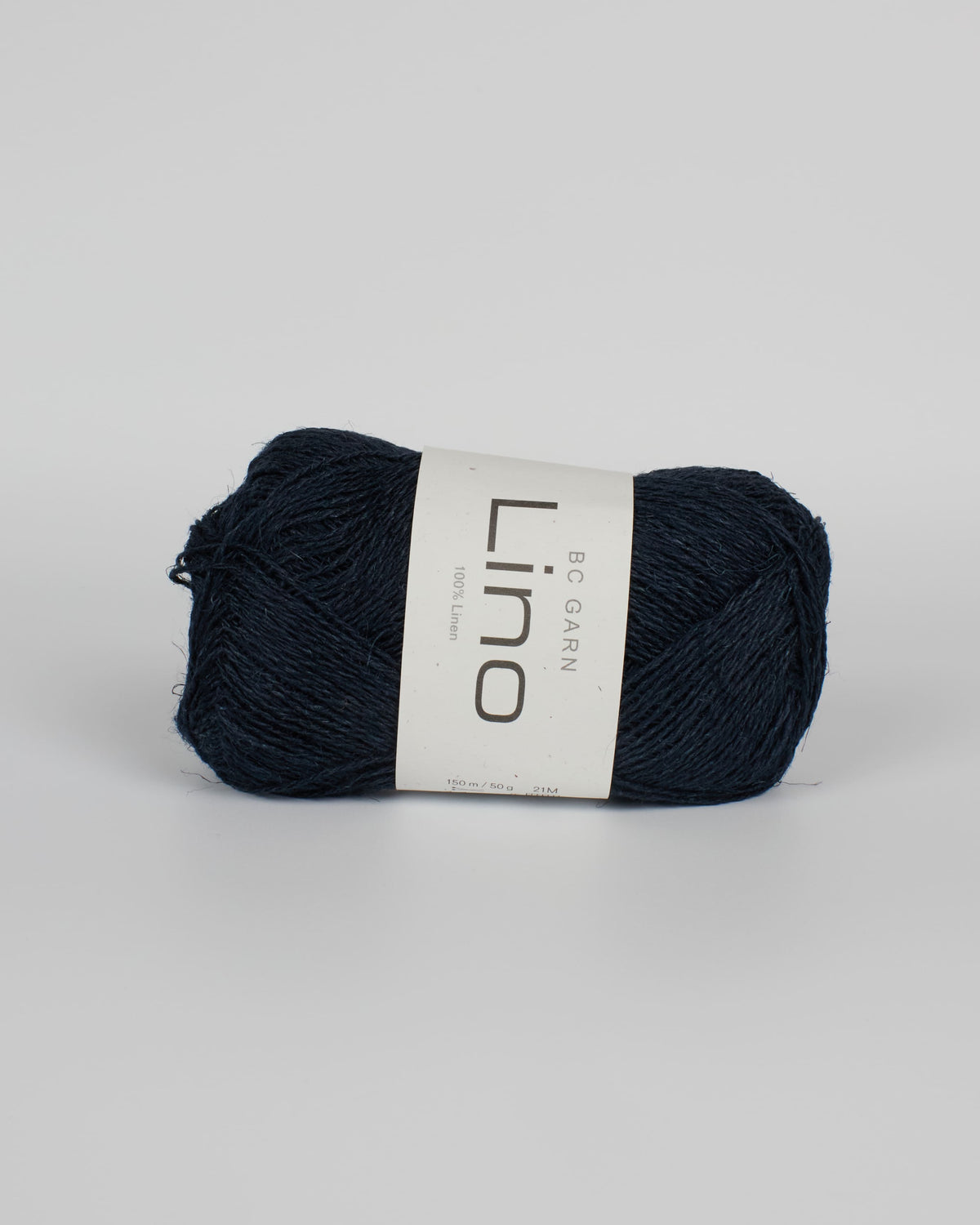 A navy blue ball of linen yarn on a white background