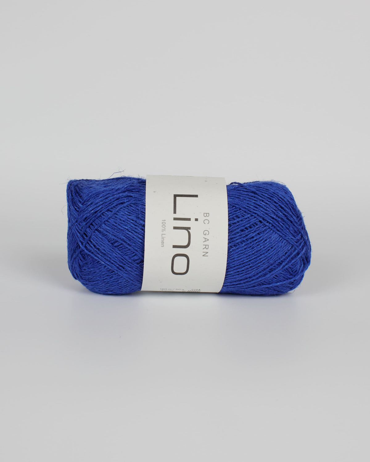 A royal blue ball of linen yarn on a white background