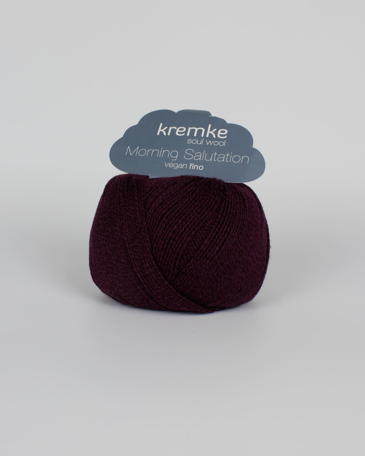 A deep purple ball of yarn on a white background