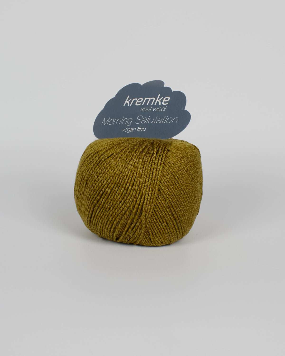 A gold green ball of yarn on a white background