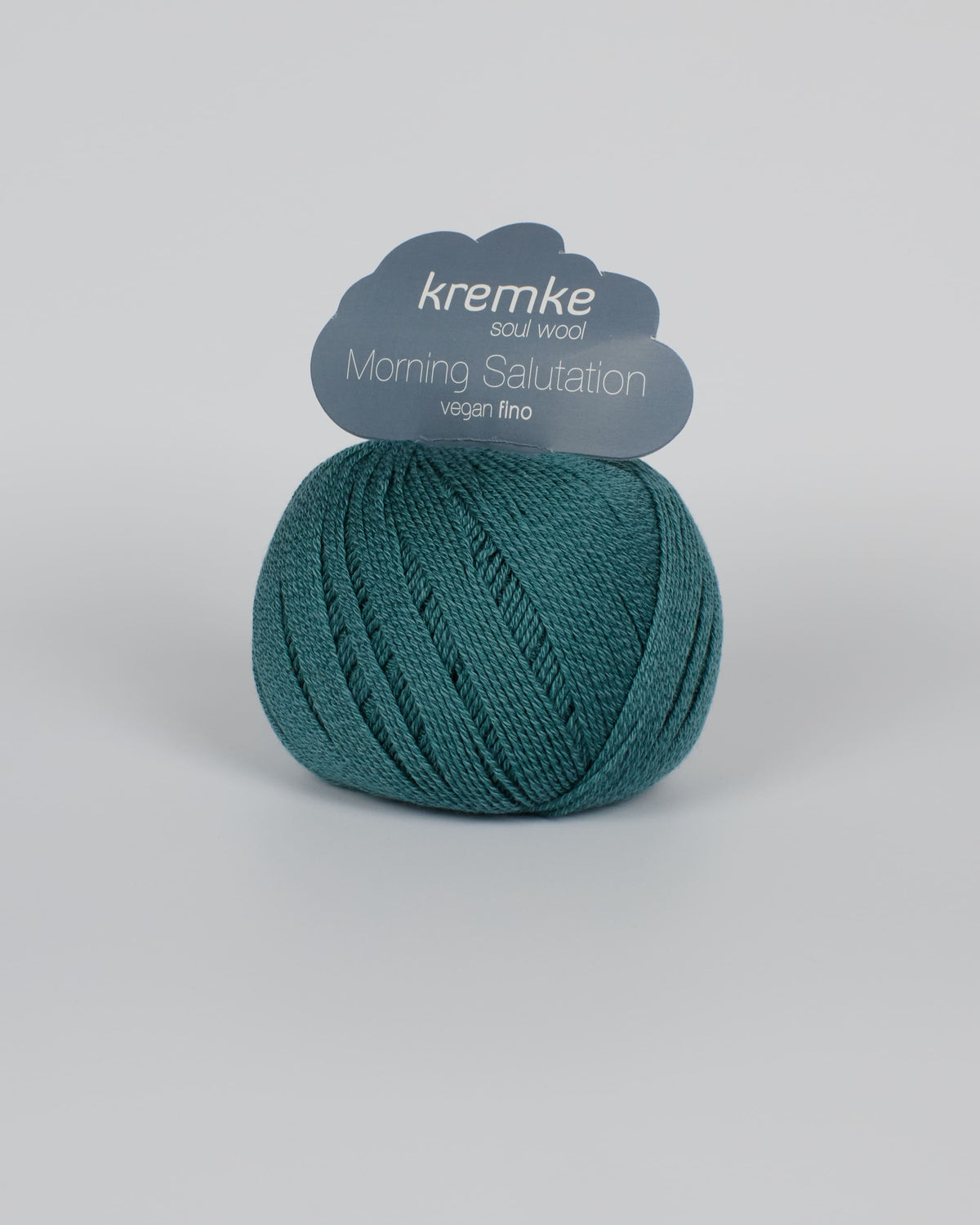 A blue green ball of yarn on a white background