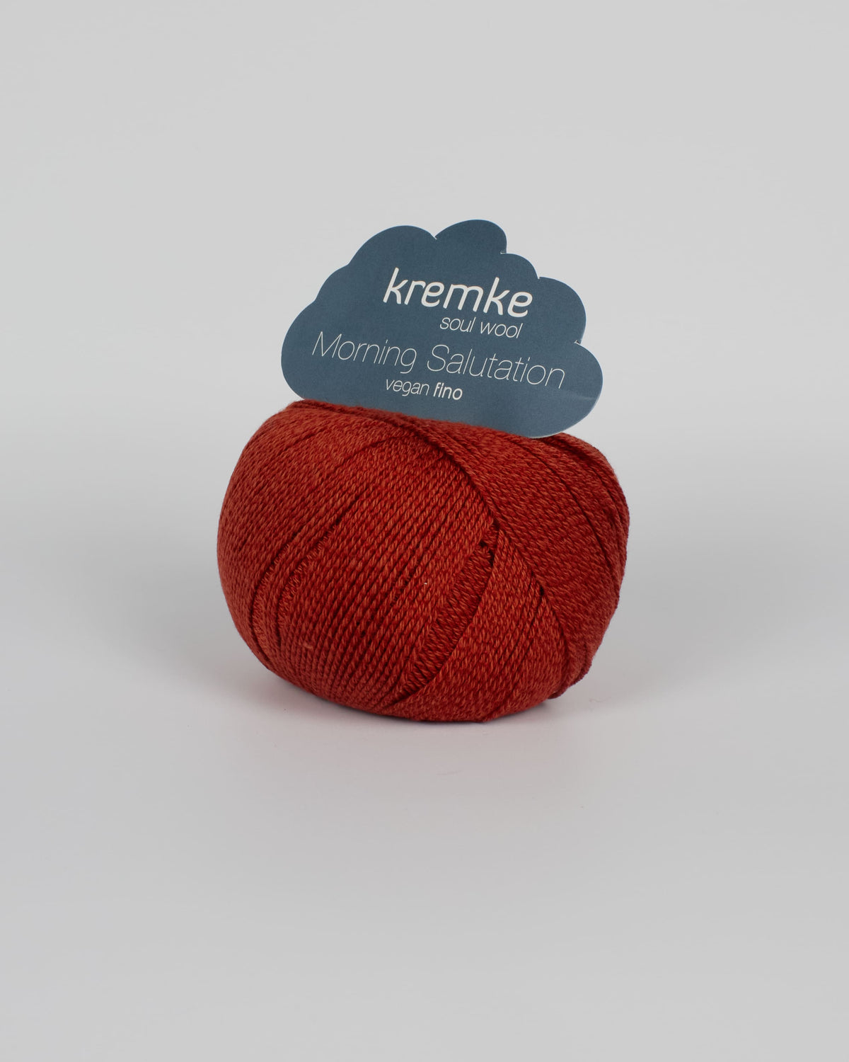 A rust red ball of yarn on a white background