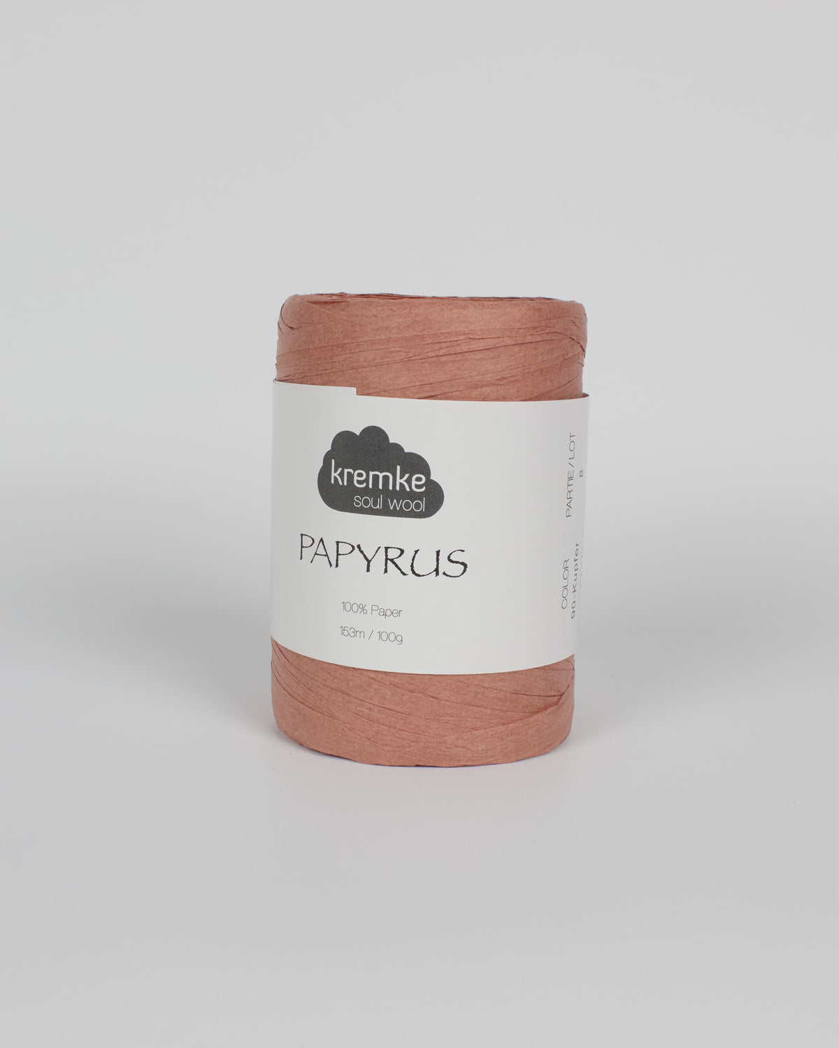 A pinky brown ball of raffia yarn on a white background