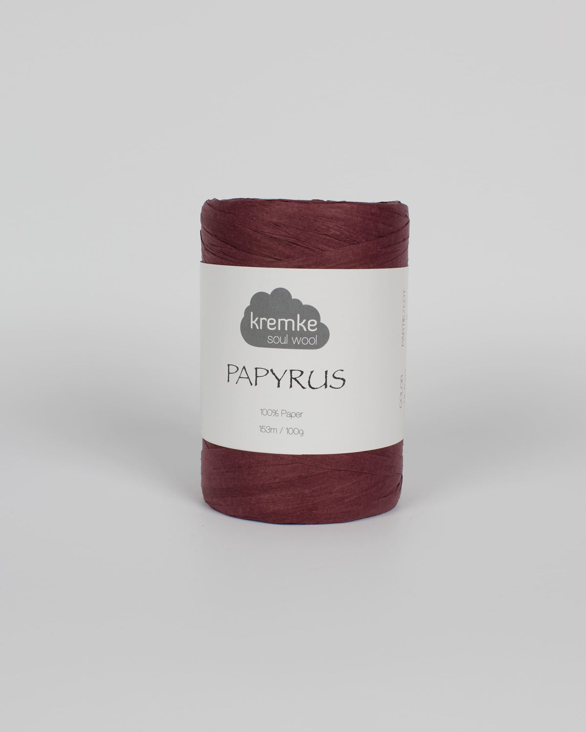 A aubergine purple ball of raffia yarn on a white background