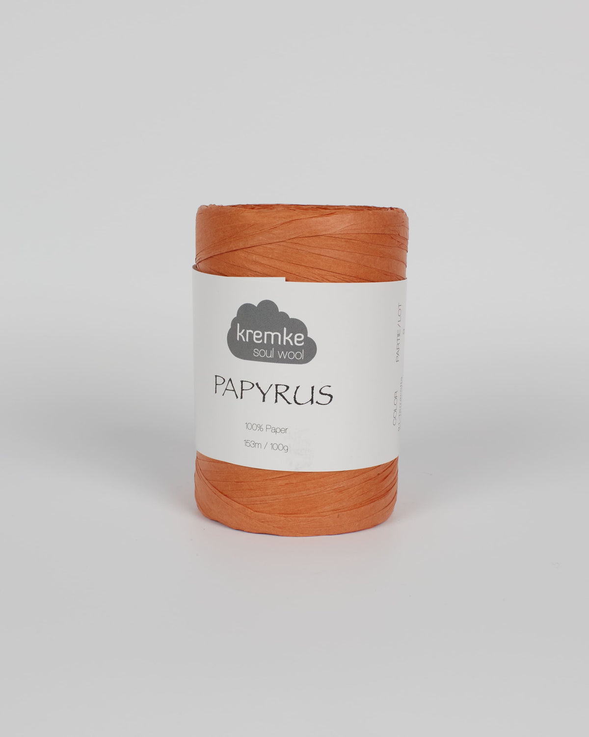 A terracotta orange ball of raffia yarn on a white background