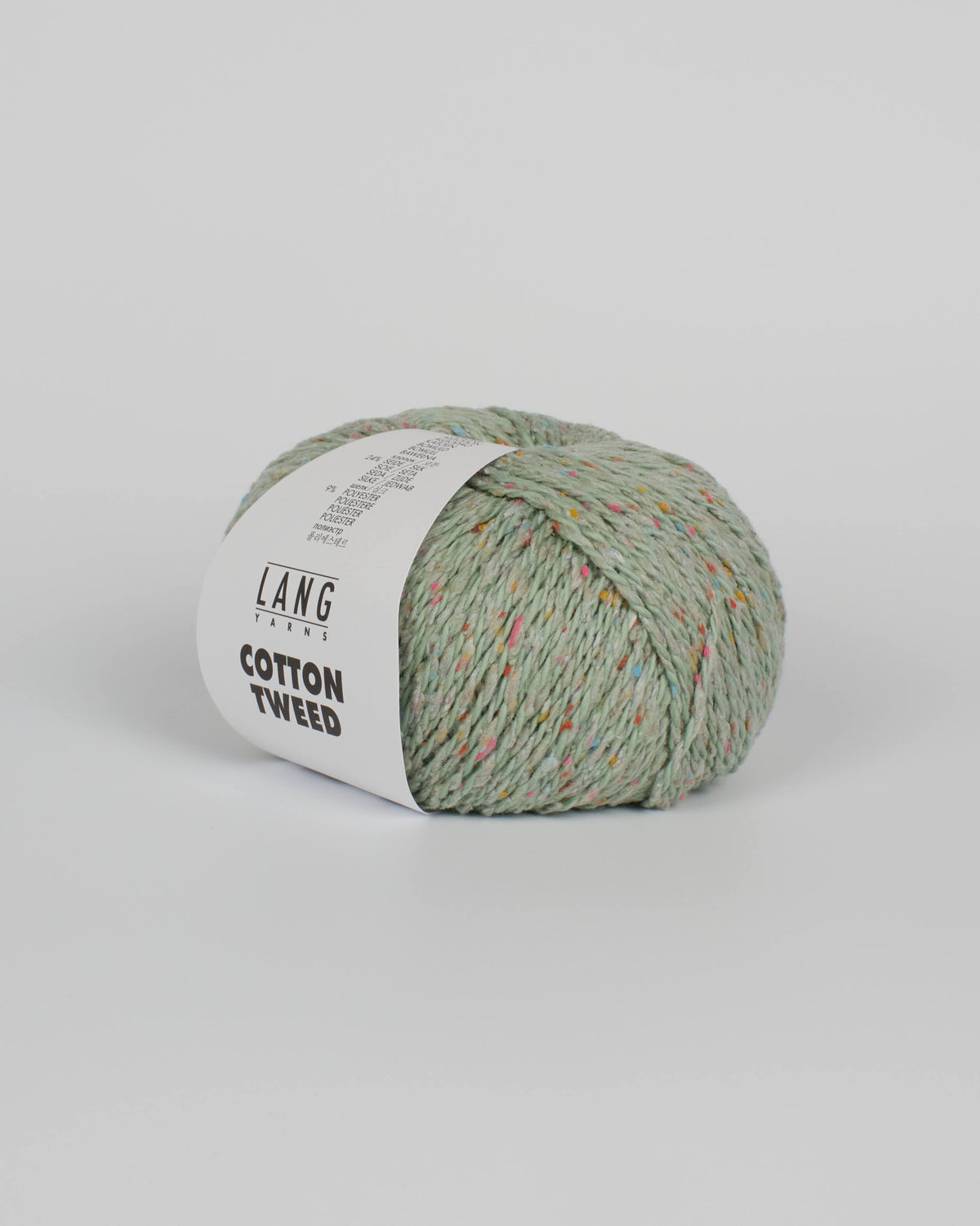 A pistachio green ball of yarn with multicoloured tweed flecks on a white background