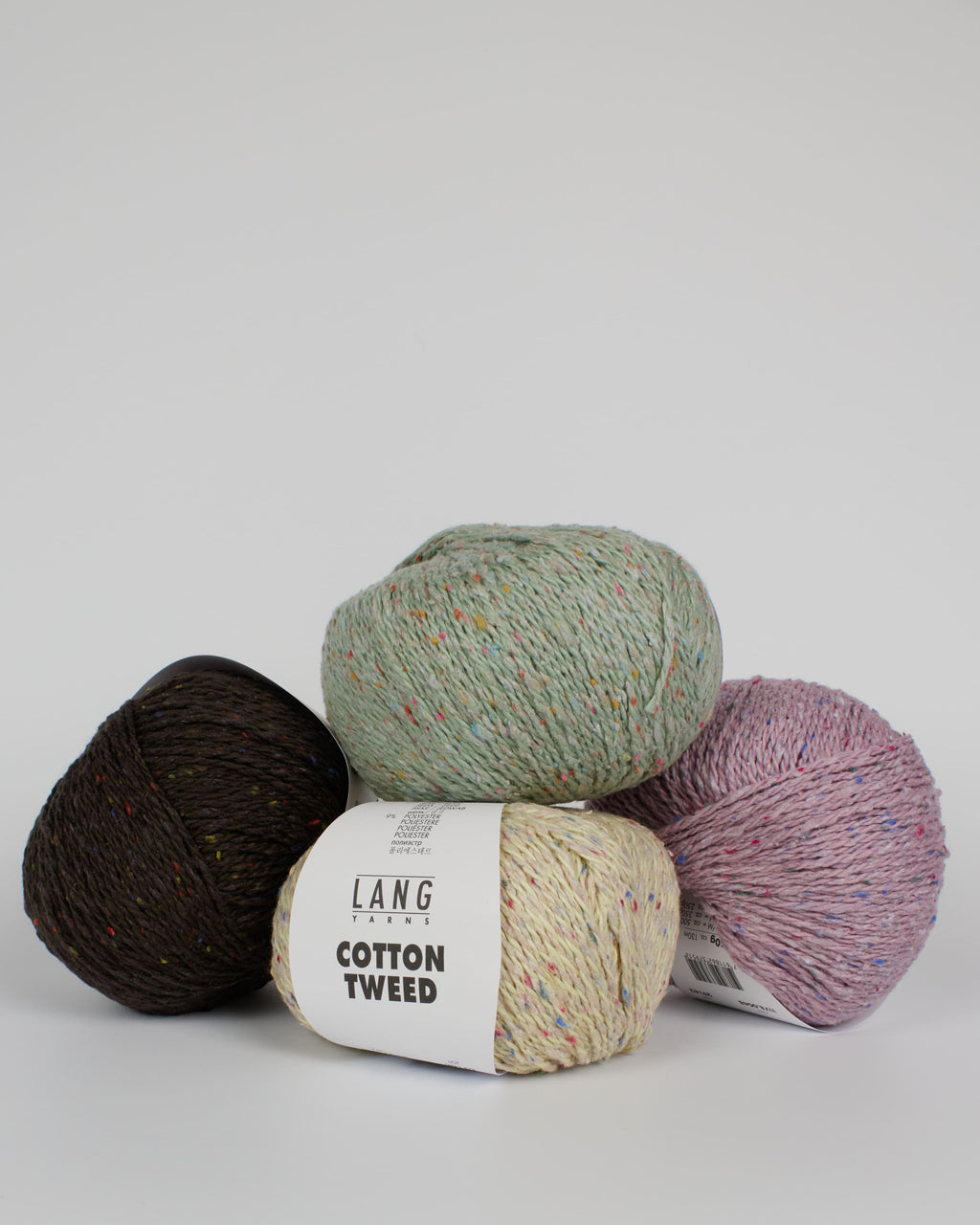 A collection of different coloured balls of yarn on a white background