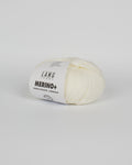 An off white ball of yarn on a white background